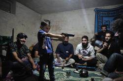Moment de détente entre compagnons de guerre. Un enfant joue au moudjahidine sous le regard de ses aînés. Moment de détente entre compagnons de guerre. Un enfant joue au moudjahidine sous le regard de ses aînés.