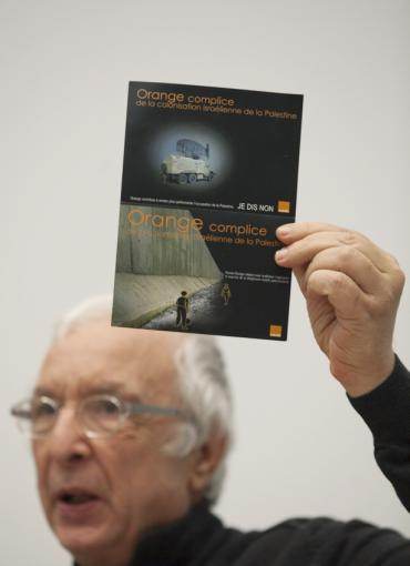 Robert Kissous de l&#039;AFPS montre la carte de la campagne pour dénoncer la complicité d&#039;Orange dans les territoires occupés.