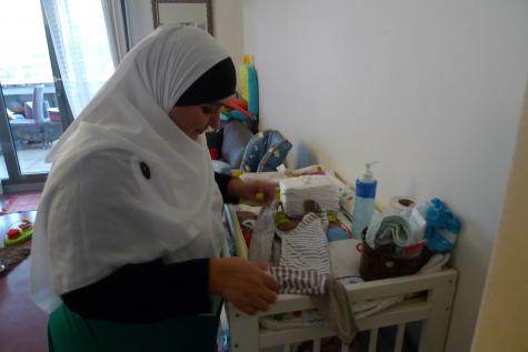 Djamila, assistante maternelle, dans son appartement. Elle porte le voile pour la photo. (CF)