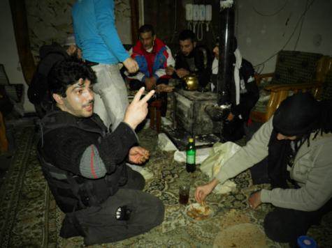Combattants de l'armée syrienne libre prenant une pause autour d'un poêle à bois