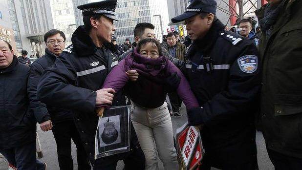 Une manifestante, venue soutenir Xu Zhiyong, est arrêtée près du tribunal.