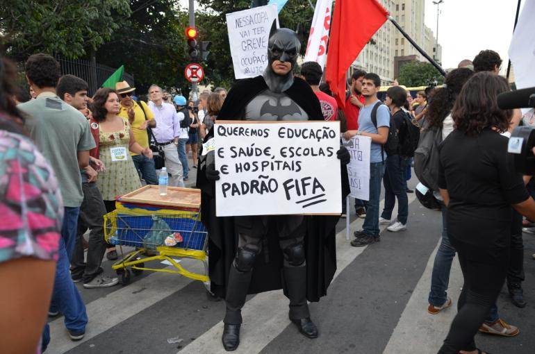 Manifestation du 15 mai à Rio. Batman et sa pancarte : «Nous voulons l&#039;éducation et la santé, des écoles et des hôpitaux»