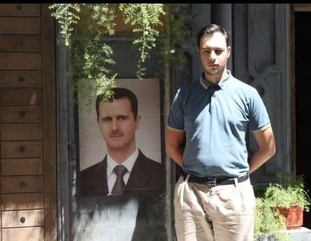 Gauthier Bouchet posant devant un portrait de Bachar El-Assad, à l&#039;été 2011, en Syrie.