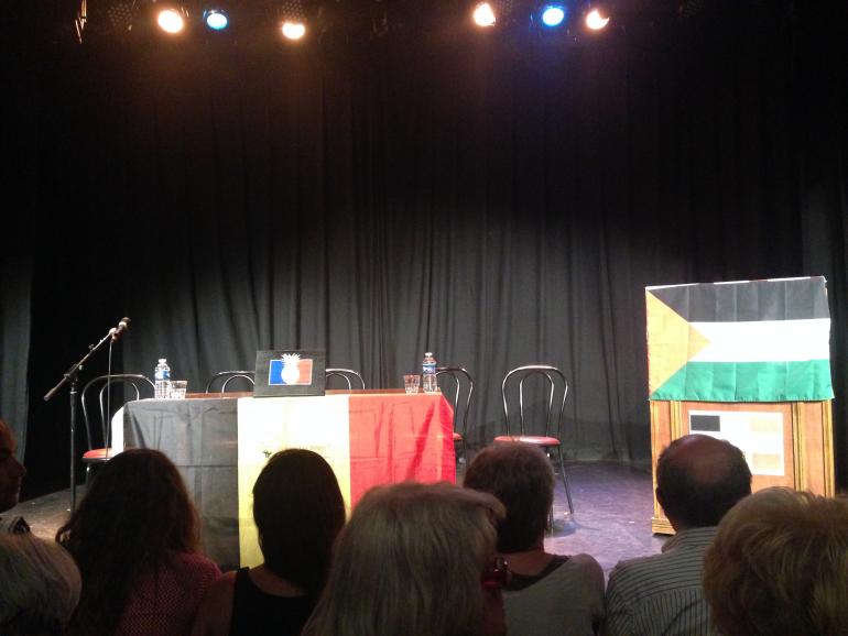 La scène du Théâtre de la Main d&#039;or, avant le début de la conférence. Au centre, un drapeau français orné d&#039;un ananas.