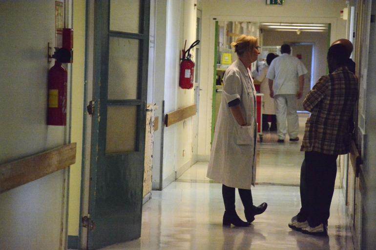 Dans les couloirs du service d’hospitalisation de jour, un médecin du service discute avec la famille d’un patient.