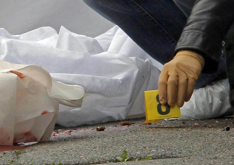 Un policier marque les traces de balles près du corps d'un homme abattu à côté de la prison des Baumettes, le 9 mars 2013.