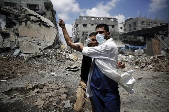 Un médecin aide un Palestinien à à Chajaya, à l'est de Gaza, le 20 juillet. Un médecin aide un Palestinien à à Chajaya, à l'est de Gaza, le 20 juillet.