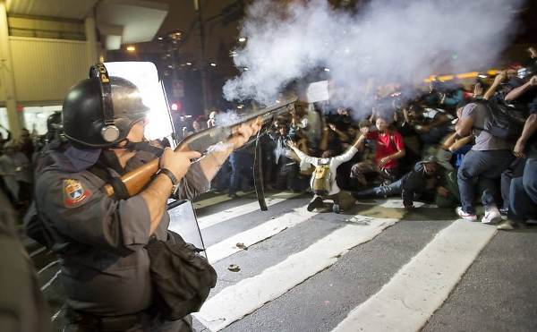 Un policier tire sur des manifestant.e.s à Sao Paulo, le 13 juin 2013