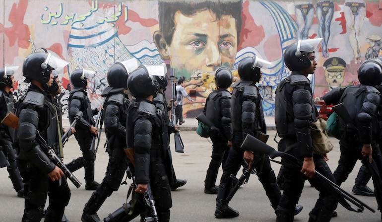 La police égyptienne devant des graffitis anti-militaristes, le 19 novembre 2014.