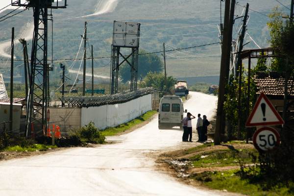 Boşin. Le camp de réfugiés entouré de barbelés. La route mène au sommet de la colline où se trouve le poste frontière. Boşin. Le camp de réfugiés entouré de barbelés. La route mène au sommet de la colline où se trouve le poste frontière.