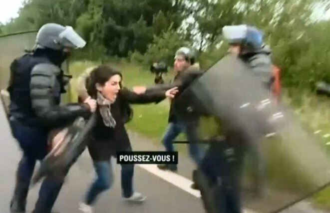 Des CRS matraquent des journalistes.