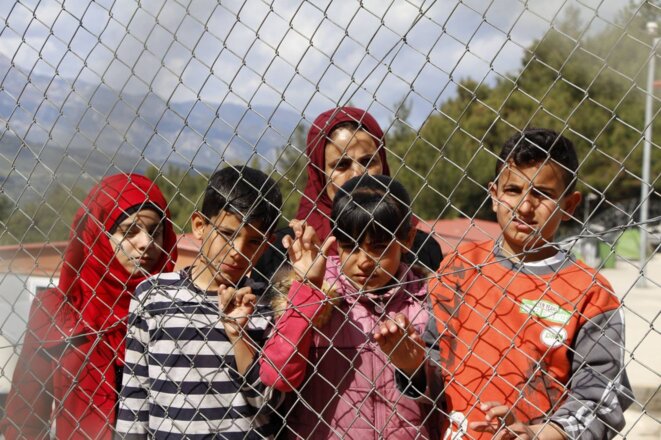 Derrière les barbelés du camp de rétention de l'île grecque de Samos, Khadija, une réfugiée syrienne veuve, et ses enfants. © Mohammad Ghannam pour MSF Derrière les barbelés du camp de rétention de l'île grecque de Samos, Khadija, une réfugiée syrienne veuve, et ses enfants. © Mohammad Ghannam pour MSF