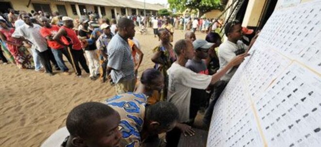 Des Togolais font la queue à Lomé, pour élire leur président, le 4 mars 2010