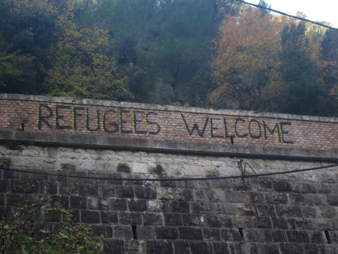 À l’entrée de la vallée de la Roya, juste après la frontière italienne, un tag souhaite la bienvenue aux réfugiés. © LF À l’entrée de la vallée de la Roya, juste après la frontière italienne, un tag souhaite la bienvenue aux réfugiés. © LF