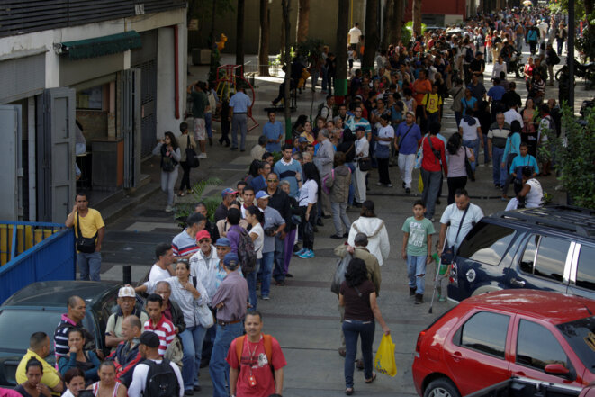 File d'attente devant une banque pour changer les billets de 100 bolivars, le 19 décembre à Caracas. © Reuters