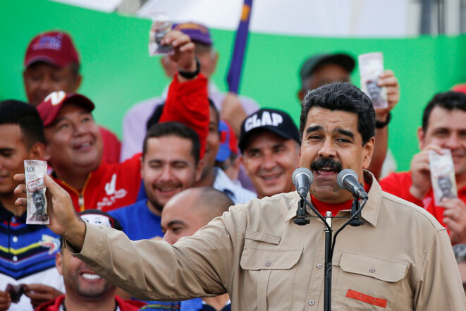 Nicolas Maduro tenant à la main un billet de 100 bolivars, retiré de la circulation. © Reuters