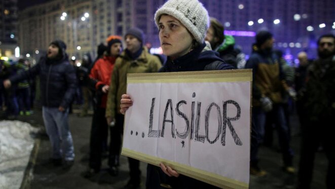 Une manifestante porte une pancarte où est inscrit le mot « Lâches », à Bucarest, le 31 janvier. © Reuters