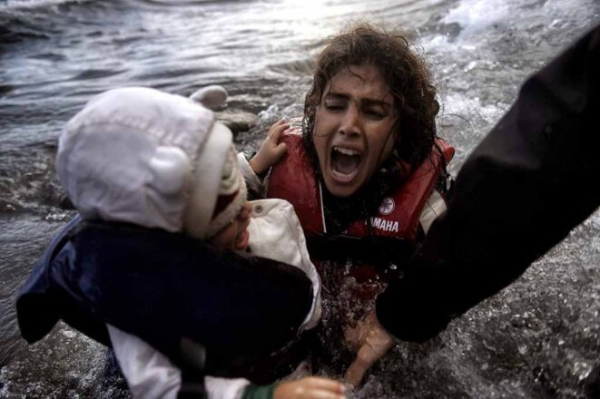 une-femme-tombe-a-l-eau-avec-son-enfant-sur-une-plage-a-lesbos-apres-avoir-traverse-la-mer-egee-octobre-2016-refugies-aris-messinis