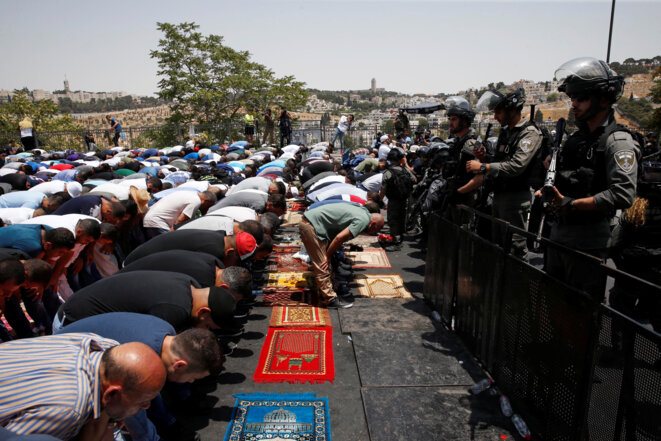 Des Palestiniens priant dans une rue près d'un barrage routier à l'extérieur de la vieille ville de Jérusalem, ce 21 juillet 2017. © REUTERS/Ronen Zvulun Des Palestiniens priant dans une rue près d'un barrage routier à l'extérieur de la vieille ville de Jérusalem, ce 21 juillet 2017. © REUTERS/Ronen Zvulun