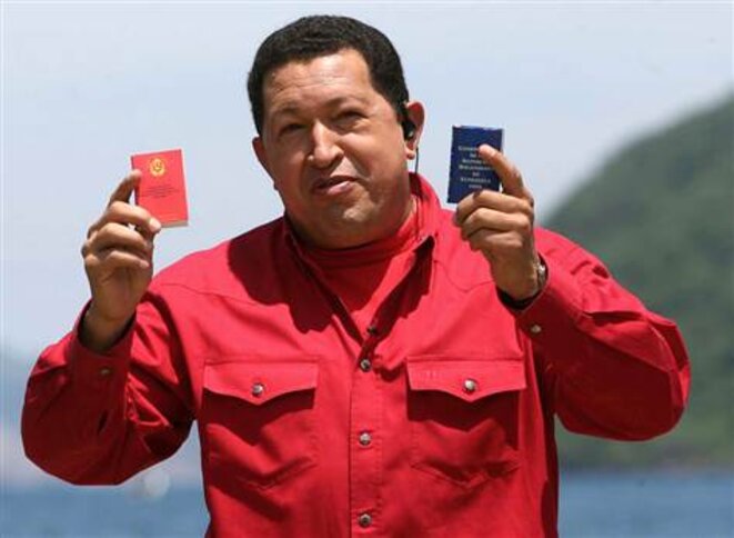 Chavez tenant la constitution de 1999 (droite) et la nouvelle (gauche) si la réforme constitutionnelle est approuvée © AFP