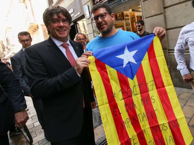 Carles Puigdemont (à gauche), le 9 juin 2017 à Barcelone, jour de l'annonce de la tenue d'une consultation le 1er octobre prochain, avec un drapeau de la Catalogne, l'Estelada, à la main © Albert Gea / Reuters. Carles Puigdemont (à gauche), le 9 juin 2017 à Barcelone, jour de l'annonce de la tenue d'une consultation le 1er octobre prochain, avec un drapeau de la Catalogne, l'Estelada, à la main © Albert Gea / Reuters.