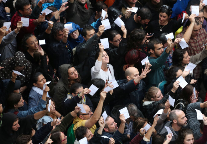 Des Catalans tenant leur bulletin de vote devant un bureau © Reuters Des Catalans tenant leur bulletin de vote devant un bureau © Reuters
