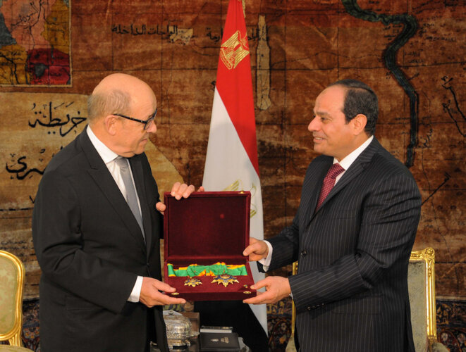 Jean-Yves Le Drian recevant des mains d'Abdelfattah al-Sissi des médailles pour le récompenser de la coopération militaire entre la France et l'Égypte, en février 2017. © Reuters
