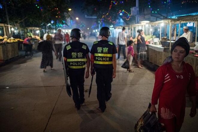 La police chinoise patrouille le marché nocturne près de la mosquée Id Kah à Kashgar, dans la région autonome ouïghoure du Xinjiang en Chine, un jour avant les vacances de l'Aïd al-Fitr, le 25 juin 2017. © AFP PHOTO / Getty Images La police chinoise patrouille le marché nocturne près de la mosquée Id Kah à Kashgar, dans la région autonome ouïghoure du Xinjiang en Chine, un jour avant les vacances de l'Aïd al-Fitr, le 25 juin 2017. © AFP PHOTO / Getty Images