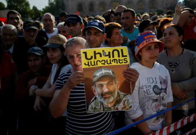 Manifestation le 2 mai 2018 à Erevan. Une participante brandit le portrait de Nikol Pachinian. © Reuters