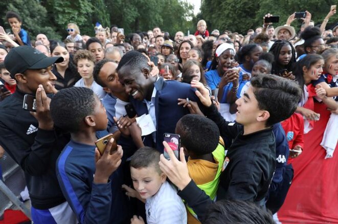Le joueur Benjamin Mendy est félicité par des supporters durant une réception à l'Élysée le 16 juillet 2018. © Ludovic Marin/Reuters Le joueur Benjamin Mendy est félicité par des supporters durant une réception à l'Élysée le 16 juillet 2018. © Ludovic Marin/Reuters