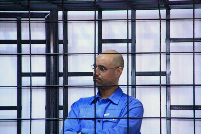 Saïf al-Islam Kadhafi, le 15 mai 2014, au tribunal de Zintane, en Libye. Saïf al-Islam Kadhafi, le 15 mai 2014, au tribunal de Zintane, en Libye.