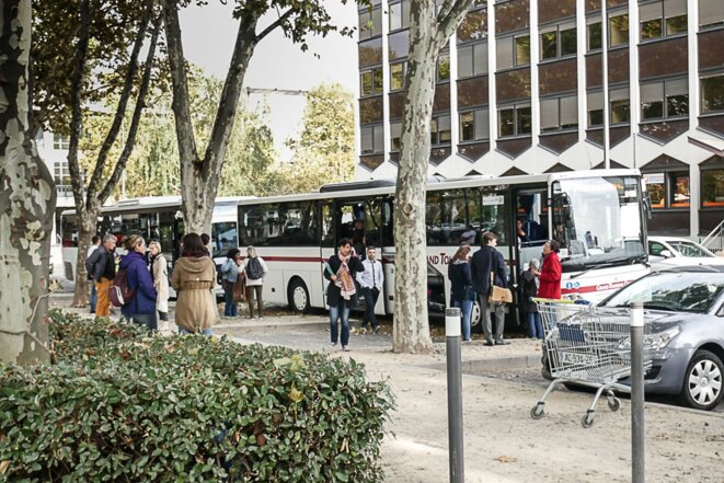 Des migrants montent dans le bus sous l'oeil de bénévoles et de fonctionnaires préfectoraux © Georges