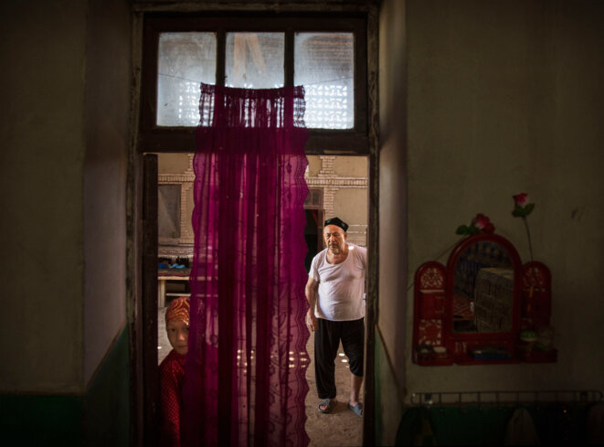 Un homme ouïghour et sa petite-fille chez eux après un repas lors de la fête Qurban à Turpan, dans le Xinjiang, le 12 septembre 2016. © Kevin Frayer/Getty Un homme ouïghour et sa petite-fille chez eux après un repas lors de la fête Qurban à Turpan, dans le Xinjiang, le 12 septembre 2016. © Kevin Frayer/Getty