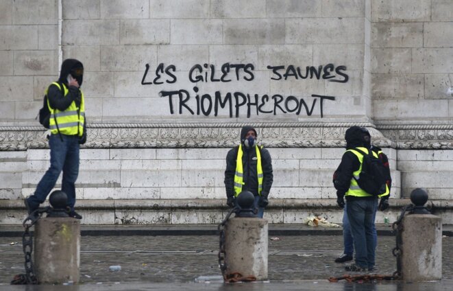 gilets-jaunes-posent-devant-tag-inscrit-arc-triomphe-paris-1er-decembre