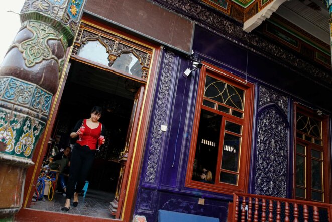 Une serveuse porte des boissons dans un bar situé dans une ancienne mosquée de la vieille ville de Kashgar. © Reuters/Thomas Peter Une serveuse porte des boissons dans un bar situé dans une ancienne mosquée de la vieille ville de Kashgar. © Reuters/Thomas Peter