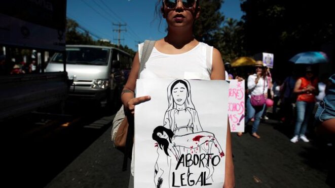une-manifestante-tient-une-pancarte-sur-l-avortement-legal-au-cours-de-la-marche-un-jour-sans-femmes-pour-la-journee-internationale-des-femmes-a-san-salvador-le-8-mars-2017-5912464