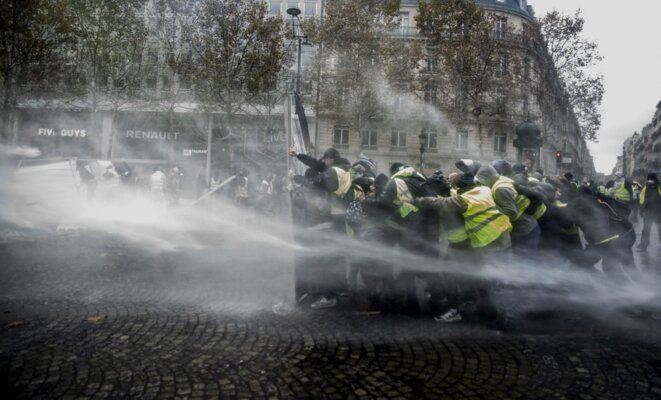 Paris, Champs Elysées le 24 novembre 2018 - Des gilets jaunes se protègent des canons à eau des CRS © SIPA Paris, Champs Elysées le 24 novembre 2018 - Des gilets jaunes se protègent des canons à eau des CRS © SIPA