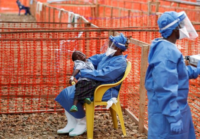 Une survivante d'Ebola tient dans ses bras un enfant suspecté d'être atteint du virus à Beni, dans la province du Nord-Kivu, le 15 décembre. © Reuters Une survivante d'Ebola tient dans ses bras un enfant suspecté d'être atteint du virus à Beni, dans la province du Nord-Kivu, le 15 décembre. © Reuters