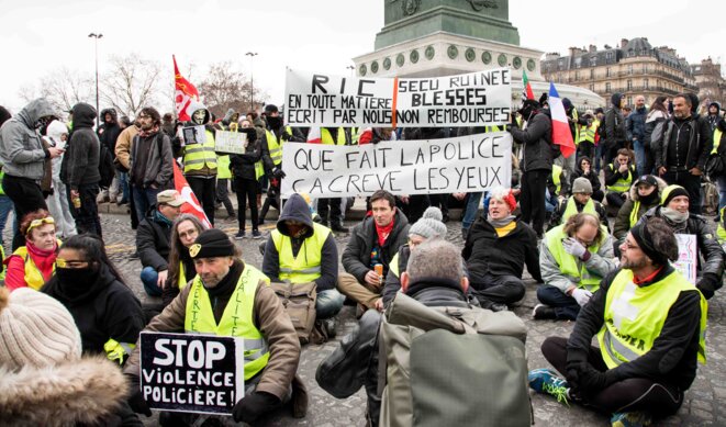 Un sitting pour dénoncer les violences policières, organisé à Paris, place de la bastille, lors de l'acte 12 des gilets jaunes © Christian DROUET Un sitting pour dénoncer les violences policières, organisé à Paris, place de la bastille, lors de l'acte 12 des gilets jaunes © Christian DROUET
