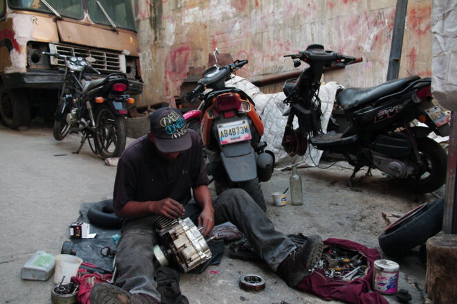 Un habitant du quartier essaie de réparer sa moto. © JBM Un habitant du quartier essaie de réparer sa moto. © JBM