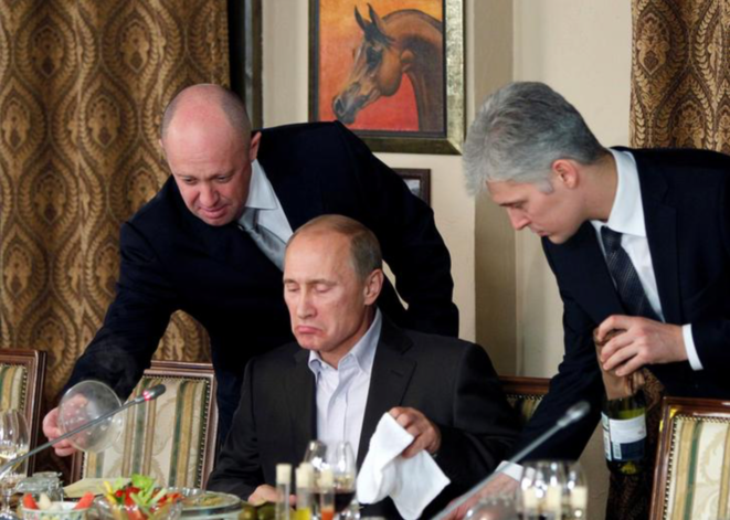 L'oligarque russe Evgeny Prigogine (à gauche) servant Vladimir Poutine. © Reuters