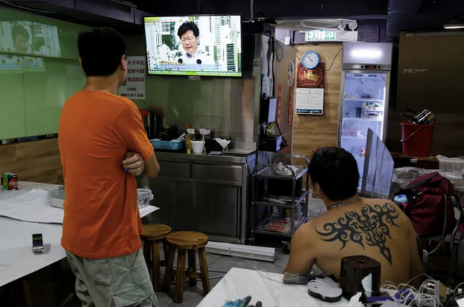 Deux hommes dans un restaurant à Hong Kong regardent l'intervention télévisée de la cheffe de l'exécutif Carrie Lam, annonçant le retrait du texte de loi prévoyant l'extradition vers la Chine, le 15 juin 2019. © REUTERS/Thomas Peter Deux hommes dans un restaurant à Hong Kong regardent l'intervention télévisée de la cheffe de l'exécutif Carrie Lam, annonçant le retrait du texte de loi prévoyant l'extradition vers la Chine, le 15 juin 2019. © REUTERS/Thomas Peter