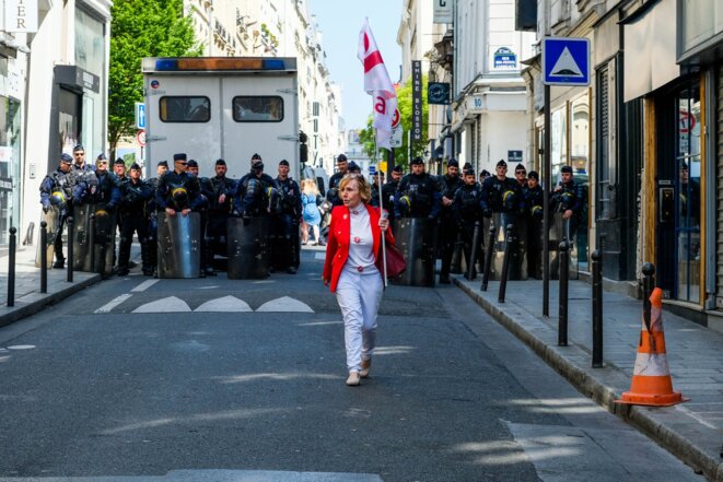 Une militante d'attac retourne vers le cortége après un échange avec les forces de l'ordre en marge de la manifestantion dite "la fête à Macron" - Paris - 5 mai 2018