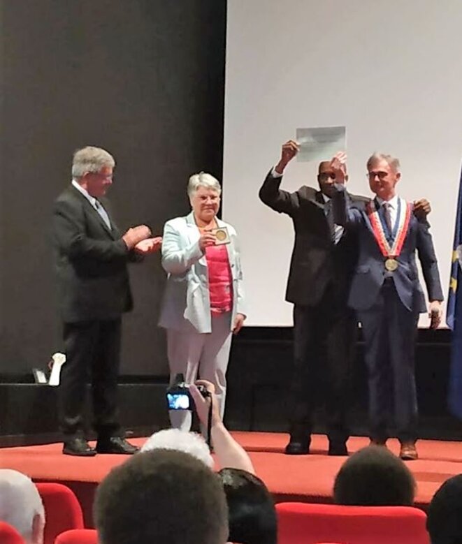 Cérémonie de remise de la distinction de citoyen d’honneur de la ville de Saint-Pol-de-Léon à M. Michel Thierry Atangana Abega par le Maire, M. Nicolas Floch. Il est entouré de Mme et M. René et Catherine Grall, qui ont lancé l’alerte sur la disparition de Michel Thierry Atangana et convaincu Nicolas Floch de mobiliser d’autres élus locaux. Cérémonie de remise de la distinction de citoyen d’honneur de la ville de Saint-Pol-de-Léon à M. Michel Thierry Atangana Abega par le Maire, M. Nicolas Floch. Il est entouré de Mme et M. René et Catherine Grall, qui ont lancé l’alerte sur la disparition de Michel Thierry Atangana et convaincu Nicolas Floch de mobiliser d’autres élus locaux.