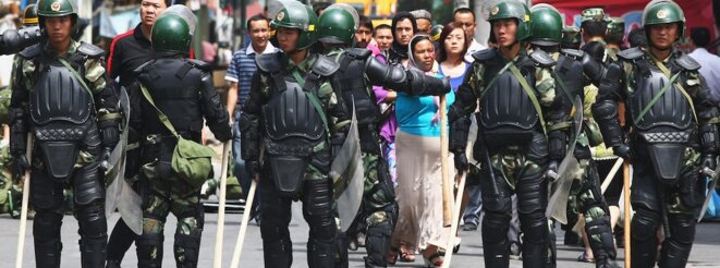 Some Uighur people walk near police as they form a line across a street on July 8, 2009 in Urumqi, the capital of Xinjiang, China. Photo by Guang Niu/Getty Images Some Uighur people walk near police as they form a line across a street on July 8, 2009 in Urumqi, the capital of Xinjiang, China. Photo by Guang Niu/Getty Images