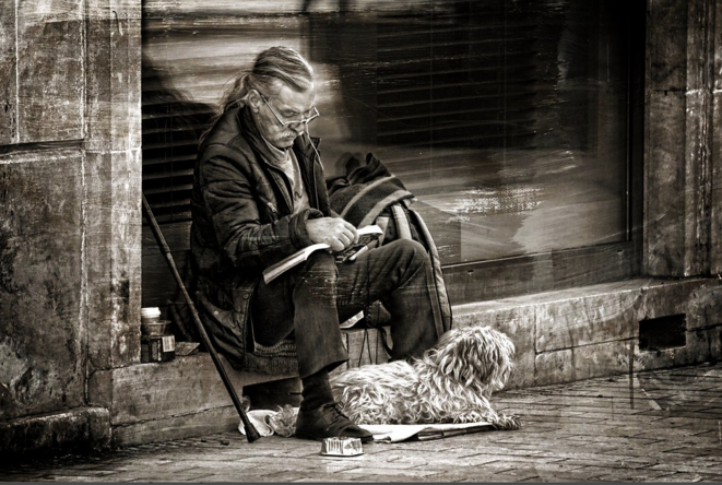 Homeless man reading and his dog © Luna TMG