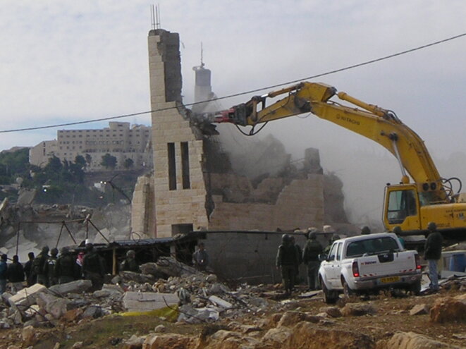 Un bulldozer israélien détruit une habitation palestinienne. © ICAHD