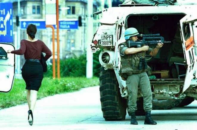 Un casque bleu à Sarajevo tente de couvrir une femme sur "Sniper alley" le 4 août 1994 Un casque bleu à Sarajevo tente de couvrir une femme sur "Sniper alley" le 4 août 1994