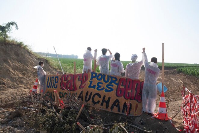 Le 26 juin 2019, des opposants à la gare promise par le gouvernement aux promoteurs d’EuropaCity déploient une banderole « Une gare pour les gens, pas pour Auchan » © Sophie Deiss Le 26 juin 2019, des opposants à la gare promise par le gouvernement aux promoteurs d’EuropaCity déploient une banderole « Une gare pour les gens, pas pour Auchan » © Sophie Deiss