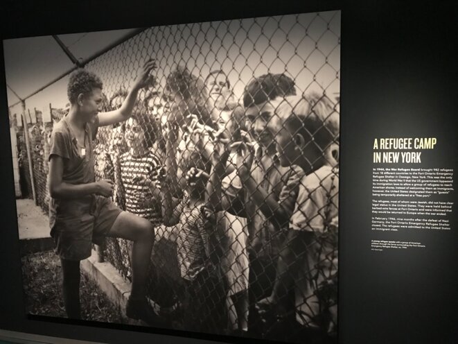 Un camp de réfugiés, Fort Ontario, à New York, en 1944 : "un jeune réfugié s'entretient avec un groupe d'enfants américains à travers la clôture entourant le refuge d'urgence"